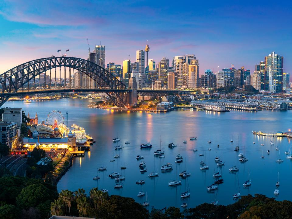 f Sydney, Australia with Harbor Bridge and Sydney skyline during sunset.