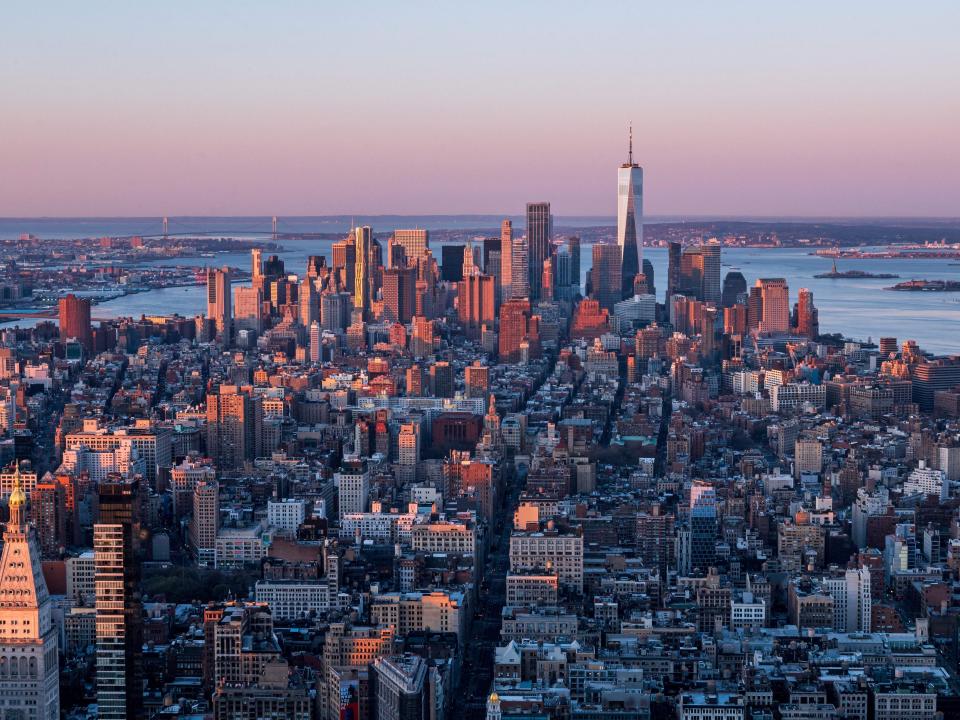 he Manhattan skyline is seen at sunrise from the 86th floor observatory of the Empire State Building on April 3, 2021, in New York City