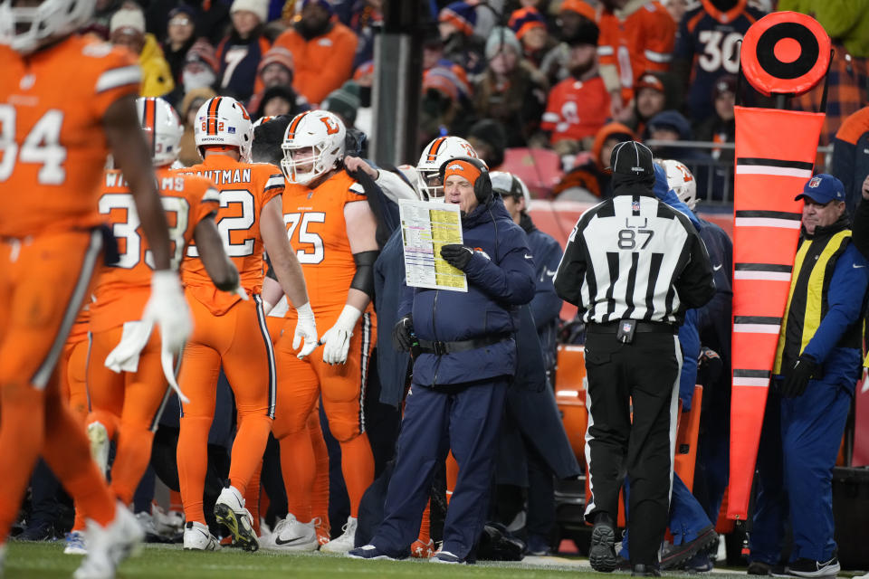 Denver Broncos head coach Sean Payton looks at his playbook during the first half of an NFL football game against the New England Patriots, Sunday, Dec. 24, 2023, in Denver. (AP Photo/David Zalubowski)