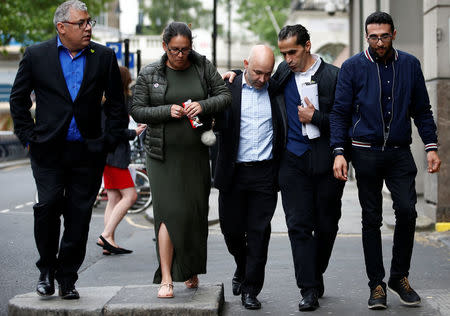 Marcio and Andreia Gomes, parents of Logan Gomes, are comforted as they arrive for a commemoration hearing at the opening of the inquiry into the Grenfell Tower disaster, in London, Britain May 21, 2018. REUTERS/Henry Nicholls