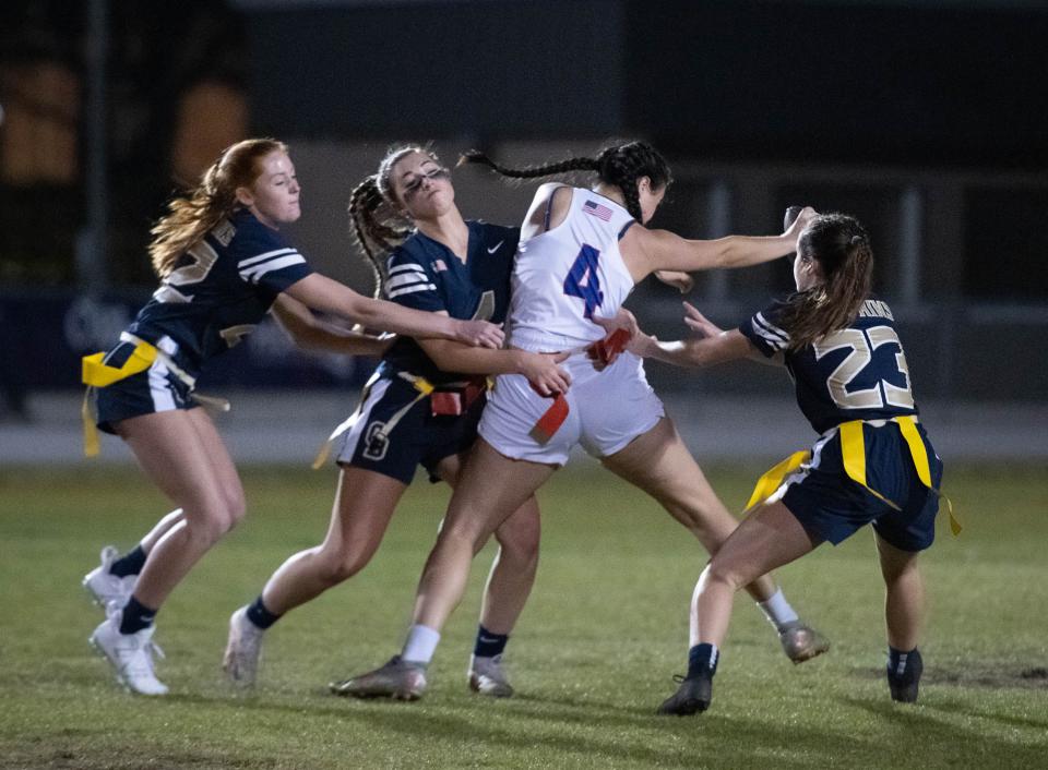 Lucy Gongwer (4) is stopped by a host of Dolphins during the Pace vs Gulf Breeze flag football at Gulf Breeze High School on Wednesday, March 22, 2023.