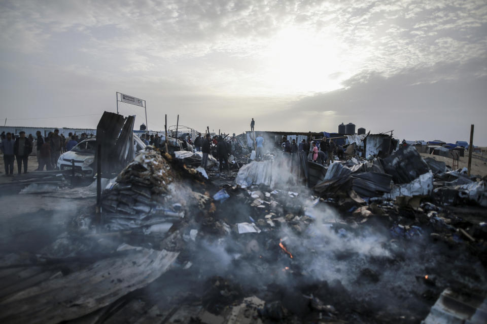 Palestinians look at the destruction after an Israeli strike where displaced people were staying in Rafah, Gaza Strip, Monday, May 27, 2024. Palestinian health workers said Israeli airstrikes killed at least 35 people in the area. Israel's army confirmed Sunday's strike and said it hit a Hamas installation and killed two senior Hamas militants. (AP Photo/Jehad Alshrafi)