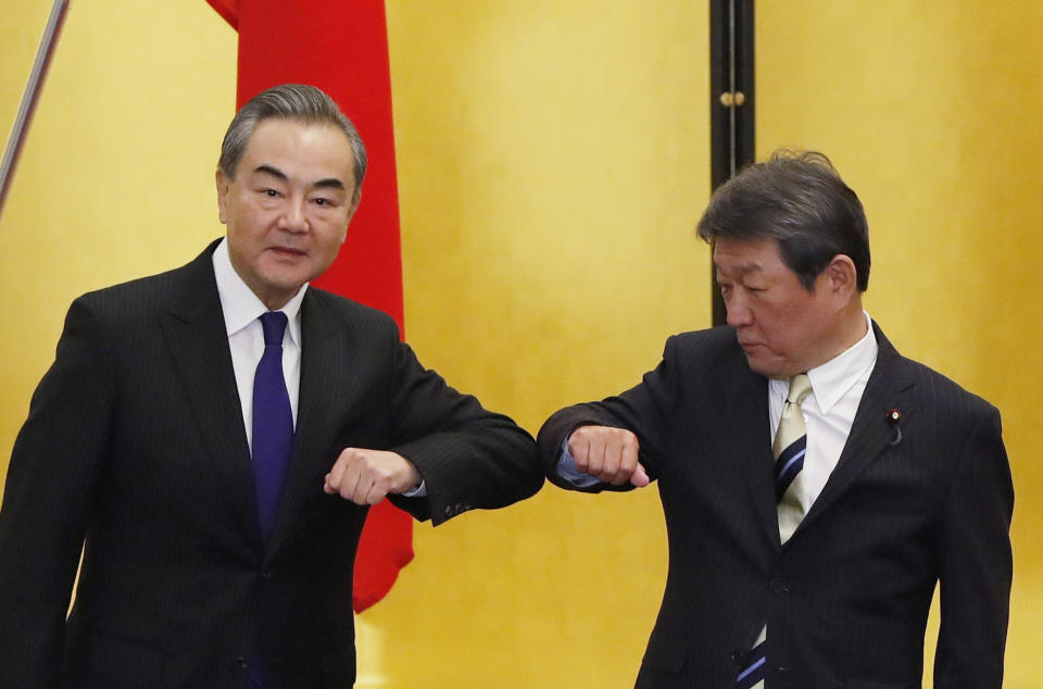 China' Foreign Minister Wang Yi, left, and his Japanese counterpart Toshimitsu Motegi bump elbows at the start of their talks amid the coronavirus outbreak, in Tokyo on Tuesday, Nov. 24, 2020. Wang met Motegi on Tuesday to discuss ways to revive their pandemic-hit economies as well as regional concerns over China’s growing influence. (Issei Kato/Pool Photo via AP)