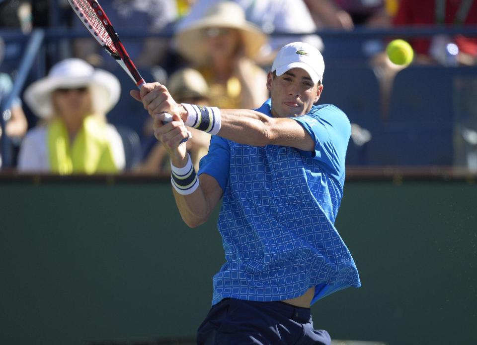 John Isner volleys with Ernests Gulbis, of Latvia, during their quarterfinal match at the BNP Paribas Open tennis tournament on Friday, March 14, 2014, in Indian Wells, Calif. (AP Photo/Mark J. Terrill)