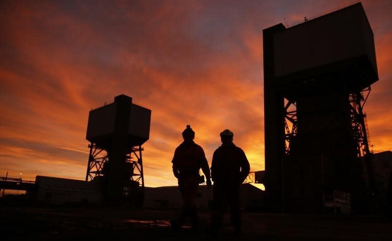 Mine workers walk towards the pit head at Kellingley Colliery on its last day of operation in north Yorkshire, England, December 18, 2015. REUTERS/Phil Noble