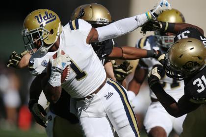 UCLA punt returner Ishmael Adams, left, breaks away for short gain from Colorado special teams player Kenneth Olugdobe in the first quarter of an NCAA football game in Boulder, Colo., on Saturday, Oct. 25, 2014. (AP Photo/David Zalubowski)