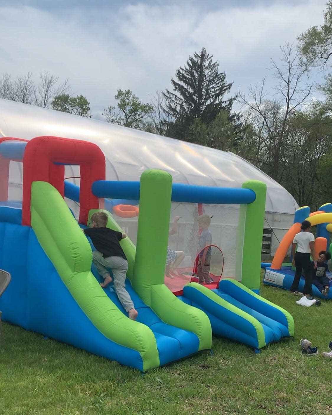 Kids jump in bounce houses during the inaugural Earth Week in the Creek event Sunday, April 28, 2024, at Sunlight Gardens.