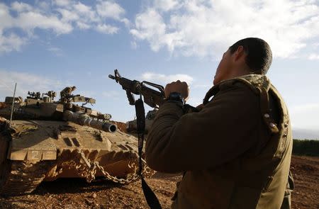 An Israeli soldier unloads his weapon near the border with Lebanon January 29, 2015. REUTERS/Baz Ratner