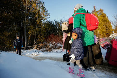 A girl waits with her family before crossing the US-Canada border into Canada in Champlain, New York, U.S., February 14, 2018. Picture taken February 14, 2018. REUTERS/Chris Wattie