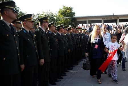 Family members walk past Turkish army officers after a funeral service for the victims of the thwarted coup, in Ankara, Turkey, July 17, 2016. REUTERS/Baz Ratner