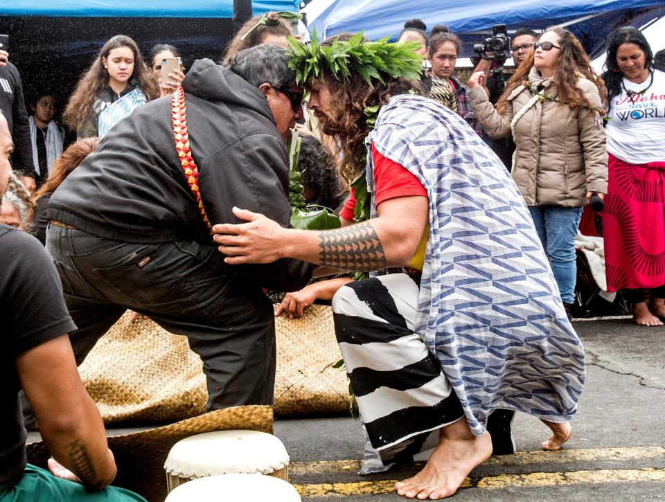 Actor Jason Momoa exchanges a traditional greeting with an elder while visiting elders and Native Hawaiian protesters blocking the construction of a giant telescope on Hawaii's tallest mountain, at Mauna Kea Access Road on Wednesday, July 31, 2019, in Mauna Kea, Hawaii.
