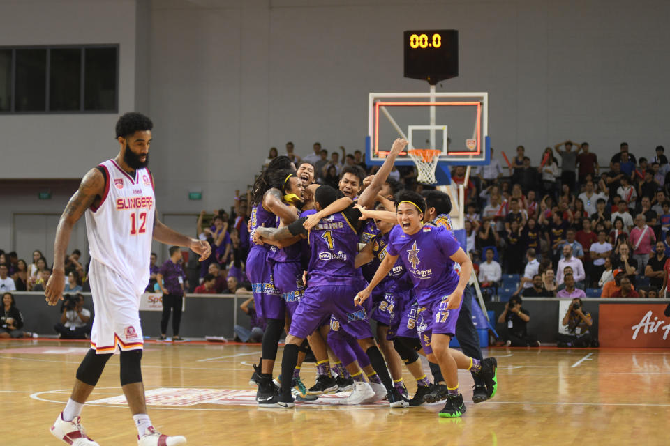 The CSL Knights Indonesia players celebrating their Asean Basketball League Finals win, as the Singapore Slingers' Jerran Young walks away from the OCBC Arena court. (PHOTO: Stefanus Ian/Yahoo News Singapore)