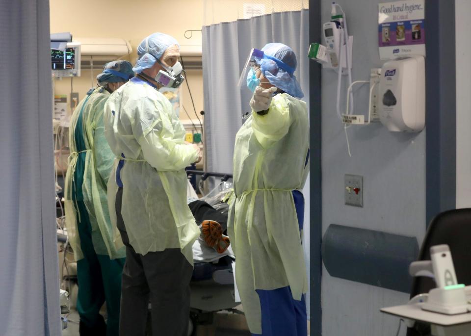 Catherine Hopkins, right, a nurse practitioner at St. Joseph's Medical Center in Yonkers, N.Y., and Dr. Anthony Leno, Director of Emergency Medical Services, speak while examining a COVID-19 patient in the hospital's emergency room on April 22, 2020.