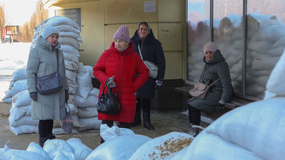 Women wait at a bus stop protected by sandbags following recent Ukrainian shelling in Belgorod, Russia, January 12, 2024. - Rueters