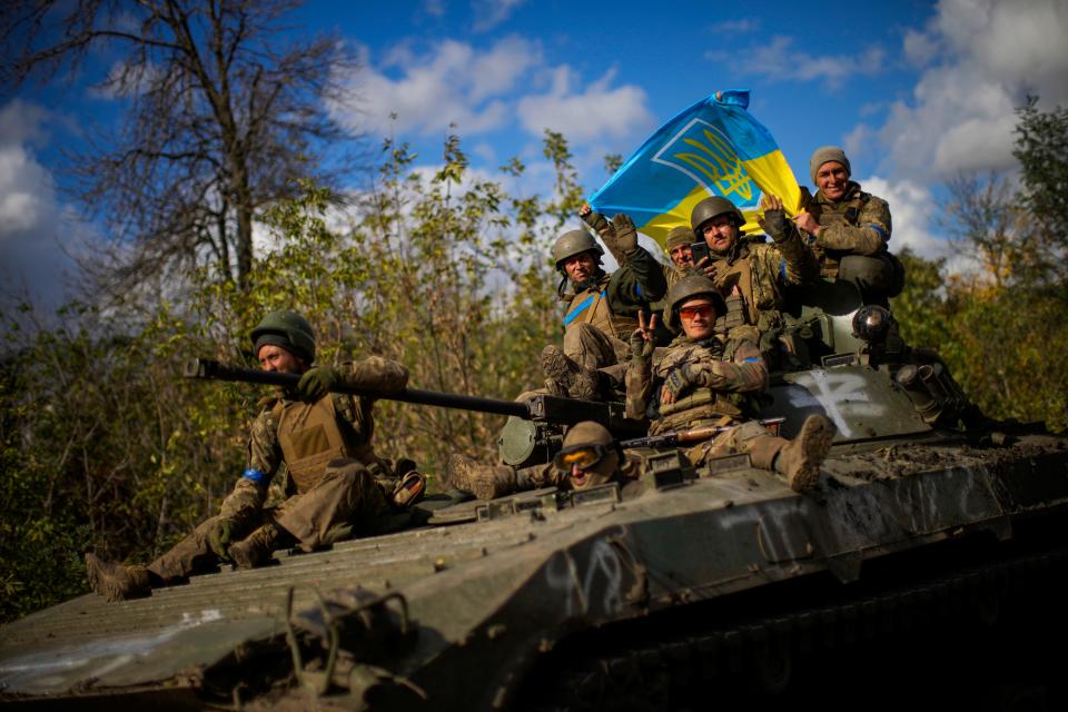 Ukrainian soldiers sit on an armored vehicle as they drive on a road between Izium and Lyman in Ukraine on Tuesday Oct. 4, 2022.