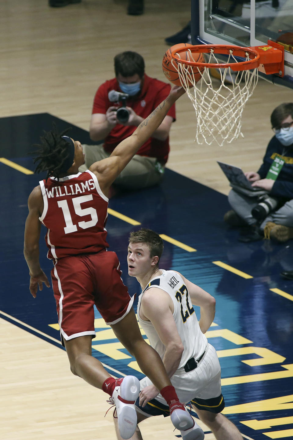 Oklahoma guard Alondes Williams (15) shoots over West Virginia guard Sean McNeil (22) during the first half of an NCAA college basketball game Saturday, Feb. 13, 2021, in Morgantown, W.Va. (AP Photo/Kathleen Batten)