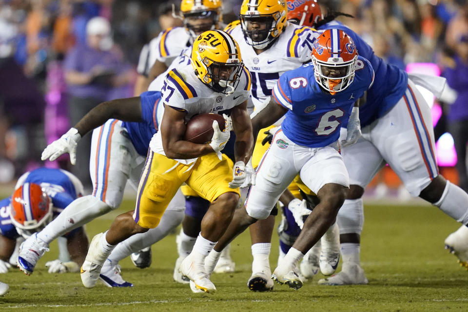 LSU running back Josh Williams (27) gains yardage as he gets past Florida linebacker Shemar James (6) during the first half of an NCAA college football game, Saturday, Oct. 15, 2022, in Gainesville, Fla. (AP Photo/John Raoux)