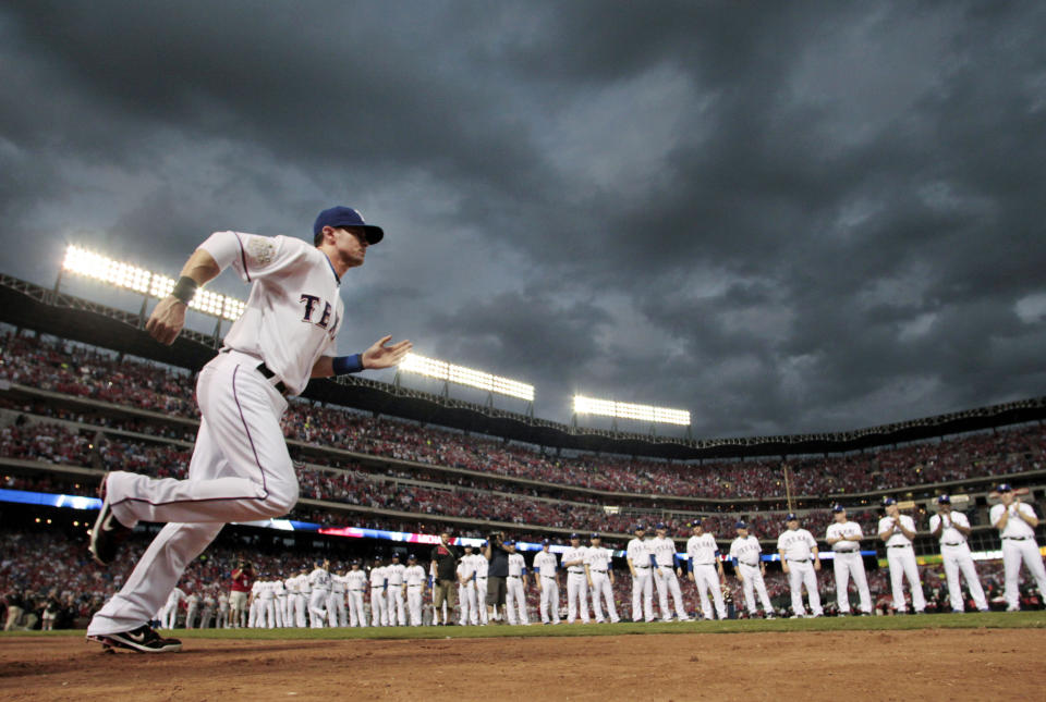 FILE - In this Oct. 22, 2011, file photo, Texas Rangers' Michael Young is introduced before Game 3 of baseball's World Series against the St. Louis Cardinals in Arlington, Texas. Young is retiring after a 13-year major league career, nearly all of it with the Rangers. The seven-time All-Star retires with a .300 career average and as Texas' hits leader with 2,230. He was the 2008 AL Gold Glove at shortstop. (AP Photo/Charlie Riedel, File)