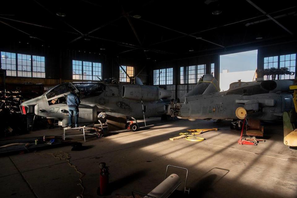 Work takes place on vintage helicopters inside Castle Air Museum’s restoration hanger in Atwater, Calif., on Wednesday, Jan. 12, 2022. According to Castle Air Museum Chief Executive Director Joe Pruzzo, the Bell AH-1W Cobra attack helicopter, left, and the SH-60B Seahawk helicopter, right, were acquired from Hawaii in 2021. When ready, the aircraft will be displayed on the Castle Air Museum grounds along with dozens of other vintage aircraft.