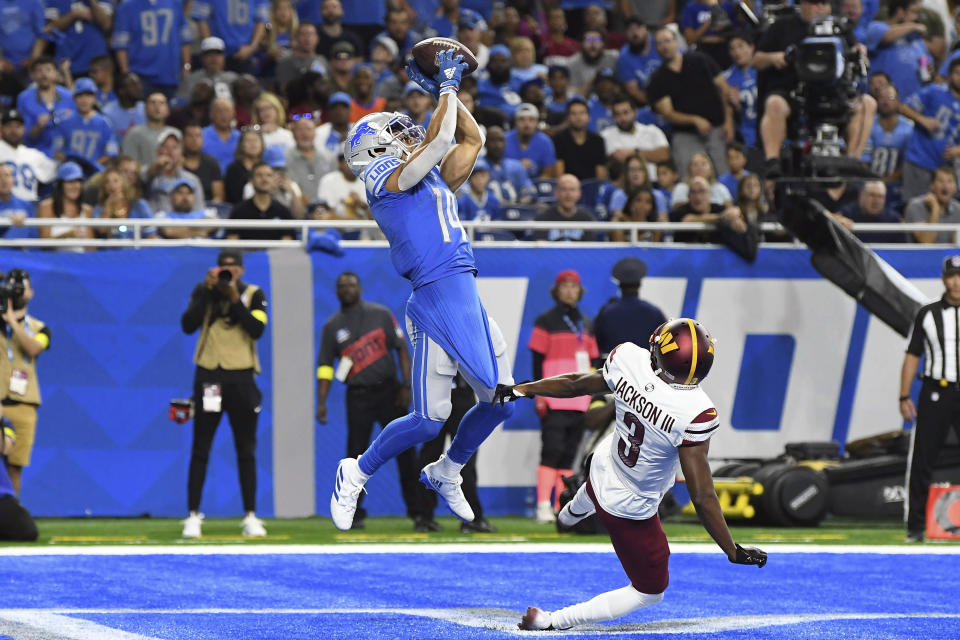 Detroit Lions wide receiver Amon-Ra St. Brown (14) makes a touchdown catch against Washington Commanders cornerback William Jackson III (3) during the first half of an NFL football game Sunday, Sept. 18, 2022, in Detroit. (AP Photo/Lon Horwedel)