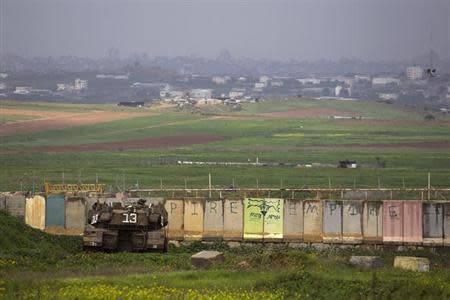 An Israeli tank is positioned outside the northern Gaza Strip March 13, 2014. REUTERS/Amir Cohen