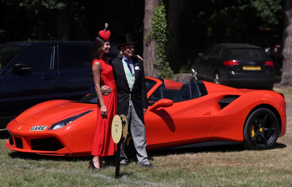 Racegoers pose with a Ferrari on Day 4.