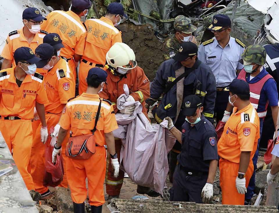 Soldiers carry bodies from the wreckage of a TransAsia Airways turboprop plane that crashed on Taiwan's offshore island Penghu July 24, 2014. The leaders of rivals China and Taiwan expressed condolences on Thursday for victims of the plane that crashed during a thunderstorm the previous day killing 48 people including two French nationals. (REUTERS/Stringer)