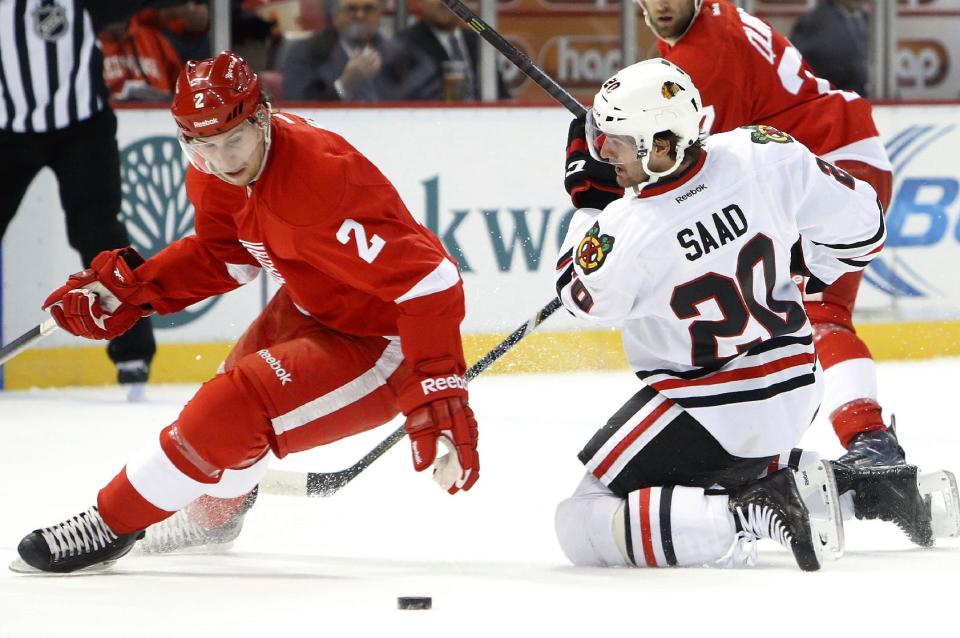 Chicago Blackhawks left wing Brandon Saad (20) loses the puck to Detroit Red Wings defenseman Brendan Smith (2) in the first period of an NHL hockey game Wednesday, Jan. 22, 2014, in Detroit. (AP Photo/Paul Sancya)