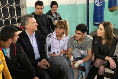 Argentina's President Mauricio Macri and Buenos Aires province governor Maria Eugenia Vidal (R) talk to young people who take boxing classes at a gym in Jose Leon Suarez, on the outskirts of Buenos Aires, Argentina August 25, 2017. Argentine Presidency/Handout via REUTERS