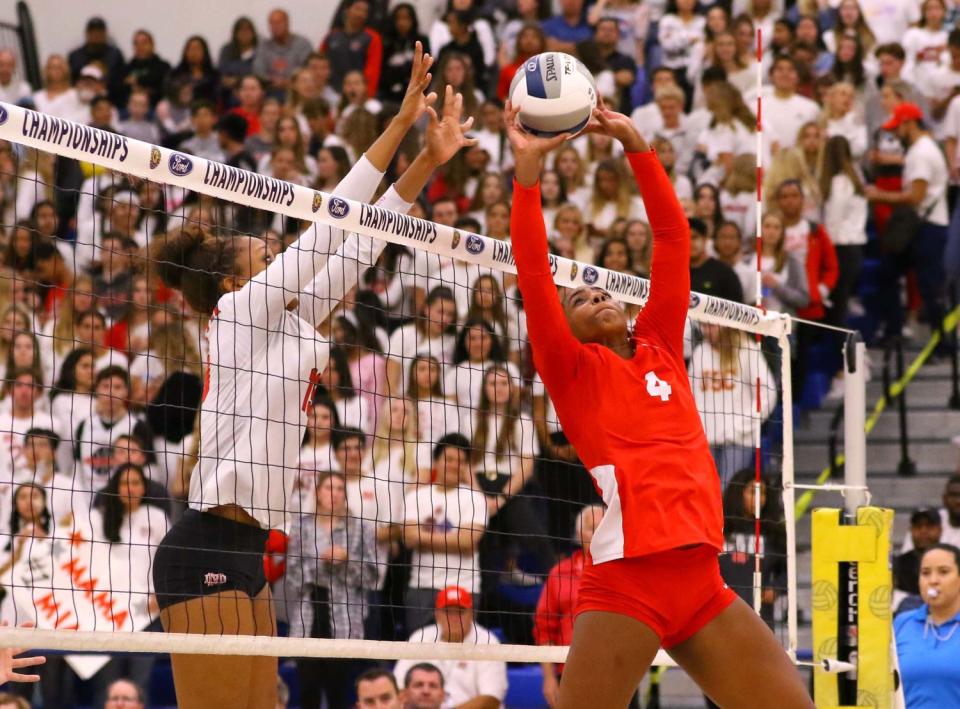 Redondo Union's Kami Miner (4) looks to set the volleyball while Mater Dei's Zaria Henderson (13) looks for a block.