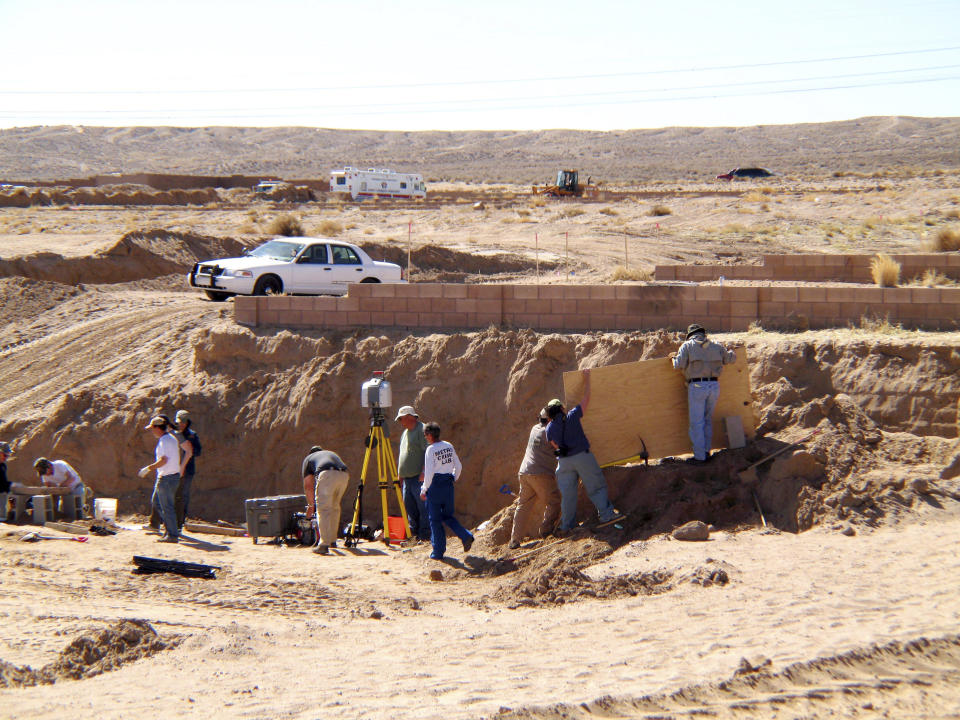 FILE - In this Feb. 28, 2009 file photo, forensic experts excavate human remains from an area that had been razed for a housing development in Albuquerque, N.M. A decade ago, Albuquerque police began unearthing the remains of 11 women and an unborn child found buried on the city's West Mesa, marking the start of a massive homicide investigation that has yet to be resolved. On the 10th anniversary of the cold case, a small group of advocates and community members plan to gather Saturday, Feb. 2, 2019, near the 2009 crime scene to remember the victims and call for more protections for marginalized and vulnerable women in New Mexico's largest city. (AP Photo/Susan Montoya Bryan, File)