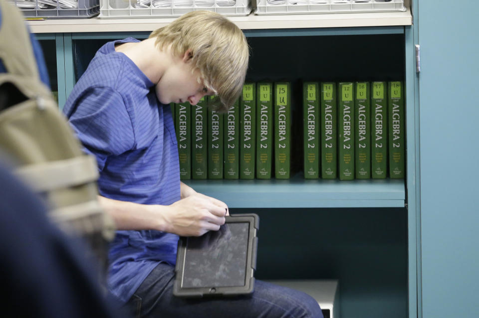 In a Wednesday, Jan. 15, 2014 photo, a high school student adjusts a tablet device in an algebra II class at Flower Mound High School in Flower Mound, Texas. Texas became the first state to require its high school students to take algebra II, betting tougher graduation standards would better prepare its youngsters for college and life beyond it. Since then, 16 other states and the District of Columbia have followed suit, and two more will by 2020. But Texas is now bucking the trend it began, abandoning advanced-math mandates to give high school students more flexibility to focus on vocational training for jobs that pay top dollar but don’t necessarily require a college degree. (AP Photo/LM Otero)