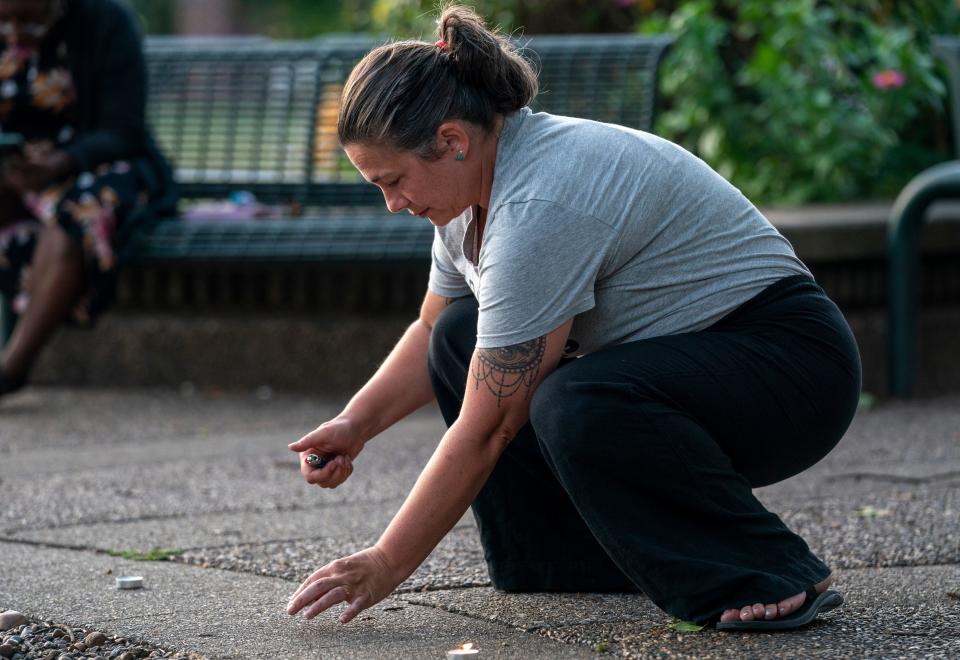 Rachel Brown lights a candle during a vigil for abortion rights in Indiana in Evansville, Ind., Tuesday, Aug. 1, 2023.