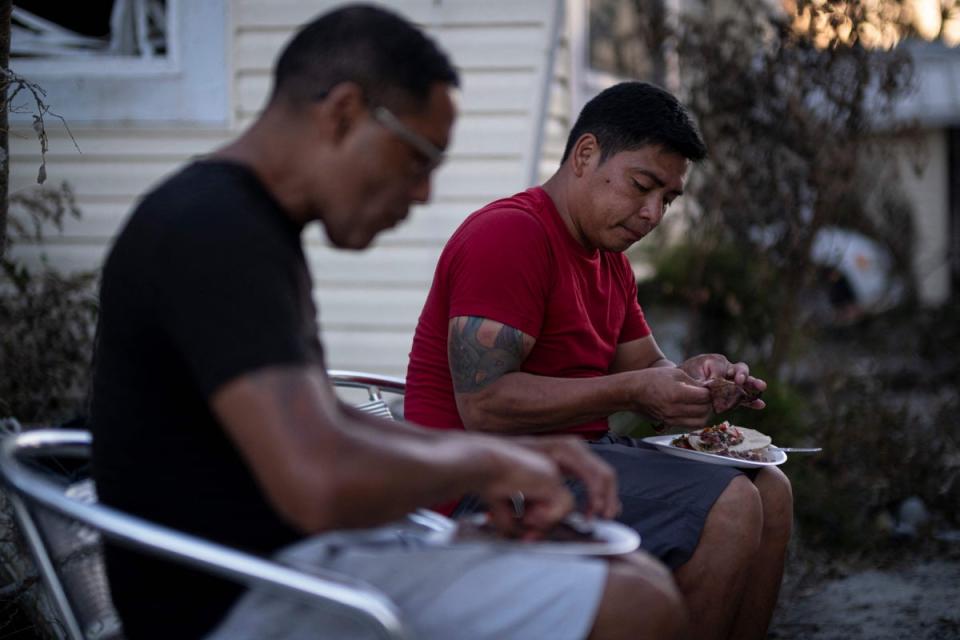 Two people eat dinner in Fort Myers Beach on Sunday as the area recovers from Hurricane Ian (AFP via Getty Images)