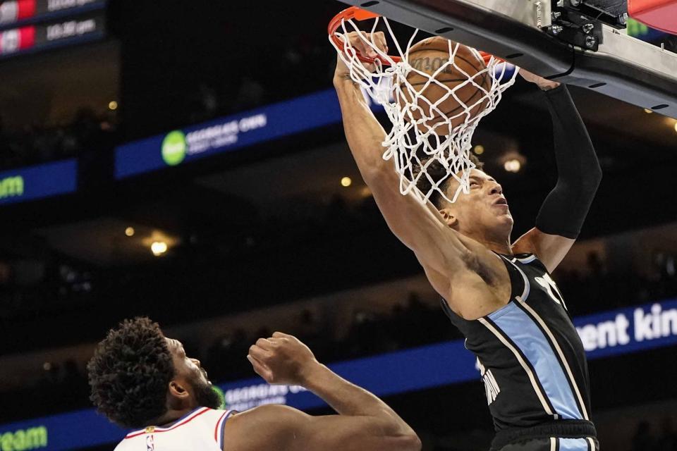 Atlanta Hawks forward Jalen Johnson (1) dunks the ball against Philadelphia 76ers center Joel Embiid (21) during the first half of an In-Season Tournament NBA basketball game, Friday, Nov. 17, 2023, in Atlanta. (AP Photo/Mike Stewart)