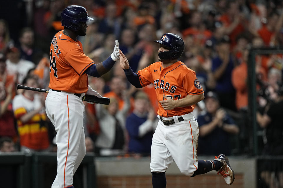 Houston Astros' Jose Altuve celebrates with Yordan Alvarez after scoring during the first inning in Game 2 of baseball's World Series between the Houston Astros and the Atlanta Braves Wednesday, Oct. 27, 2021, in Houston. (AP Photo/David J. Phillip)