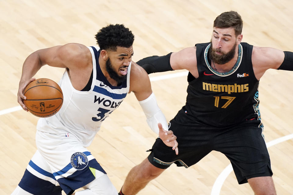 Minnesota Timberwolves' Karl-Anthony Towns (32) drives against Memphis Grizzlies' Jonas Valanciunas (17) in the second half of an NBA basketball game Friday, April 2, 2021, in Memphis, Tenn. (AP Photo/Mark Humphrey)