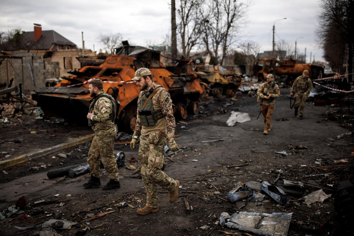 Ukrainian soldiers walk next to destroyed Russian tanks and armoured vehicles, amid Russia's invasion of Ukraine, in Bucha, in Kyiv region, Ukraine, April 6, 2022. REUTERS/Alkis Konstantinidis