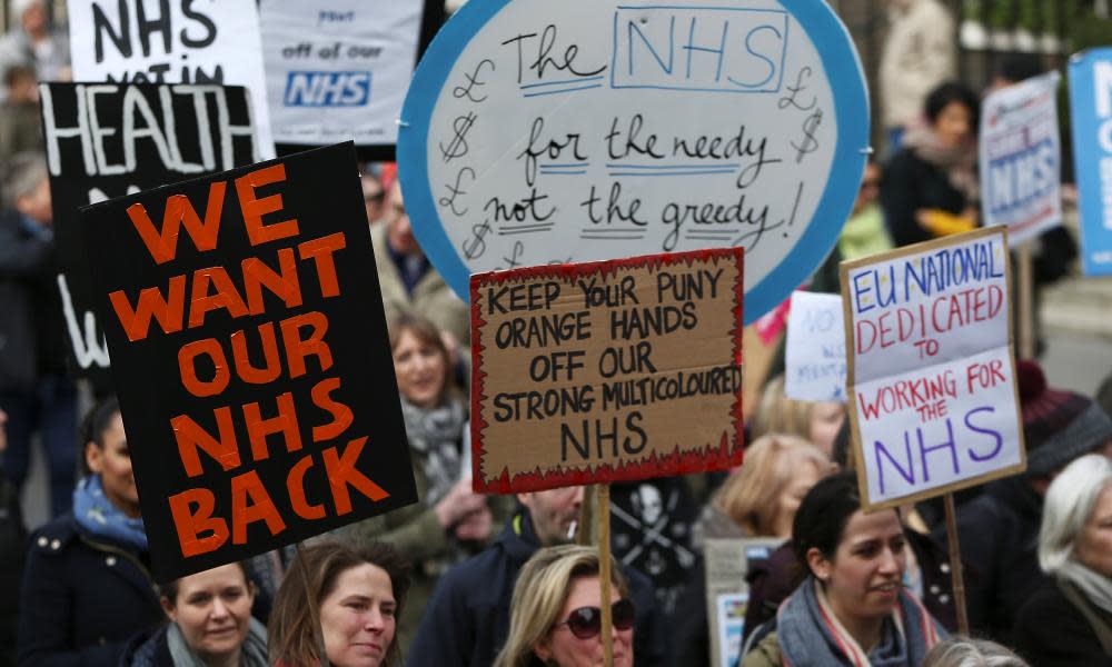 People take part in a demonstration to demand more funding for Britain’s NHS.