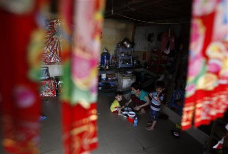 A Vietnamese woman and her son eat at their house on the banks of the Mekong river in Phnom Penh March 11, 2014. REUTERS/Samrang Pring