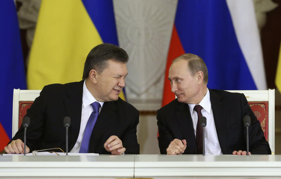 Ukrainian President Viktor Yanukovich (L) gives a wink to his Russian counterpart Vladimir Putin during a signing ceremony after a meeting of the Russian-Ukrainian Interstate Commission at the Kremlin in Moscow, December 17, 2013. Russia is planning to buy $15 billion worth of Ukraine's upcoming eurobonds using money from a sovereign wealth fund this year and next, Russian Finance Minister Anton Siluanov said on Tuesday. REUTERS/Sergei Karpukhin (RUSSIA - Tags: BUSINESS POLITICS TPX IMAGES OF THE DAY)