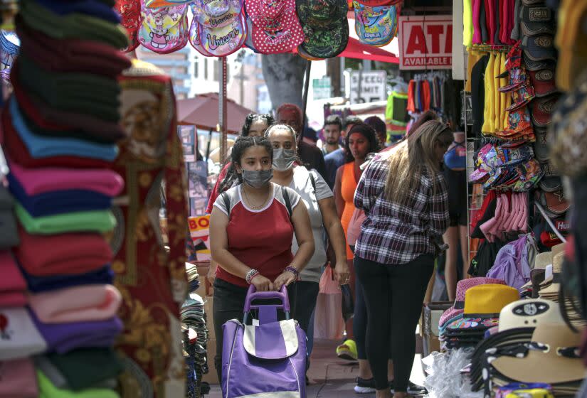 Los Angeles, CA - July 14: Sustained jumps in cases and hospitalizations fueled by the hyper-infectious BA.5 subvariant pushed Los Angeles County into the high COVID-19 community level Thursday, a shift that could trigger a new public indoor mask mandate by the end of this month unless conditions improve. Shoppers in mask and without masks in a very congested market Santee Alley on Thursday, July 14, 2022 in Los Angeles, CA. (Irfan Khan / Los Angeles Times)