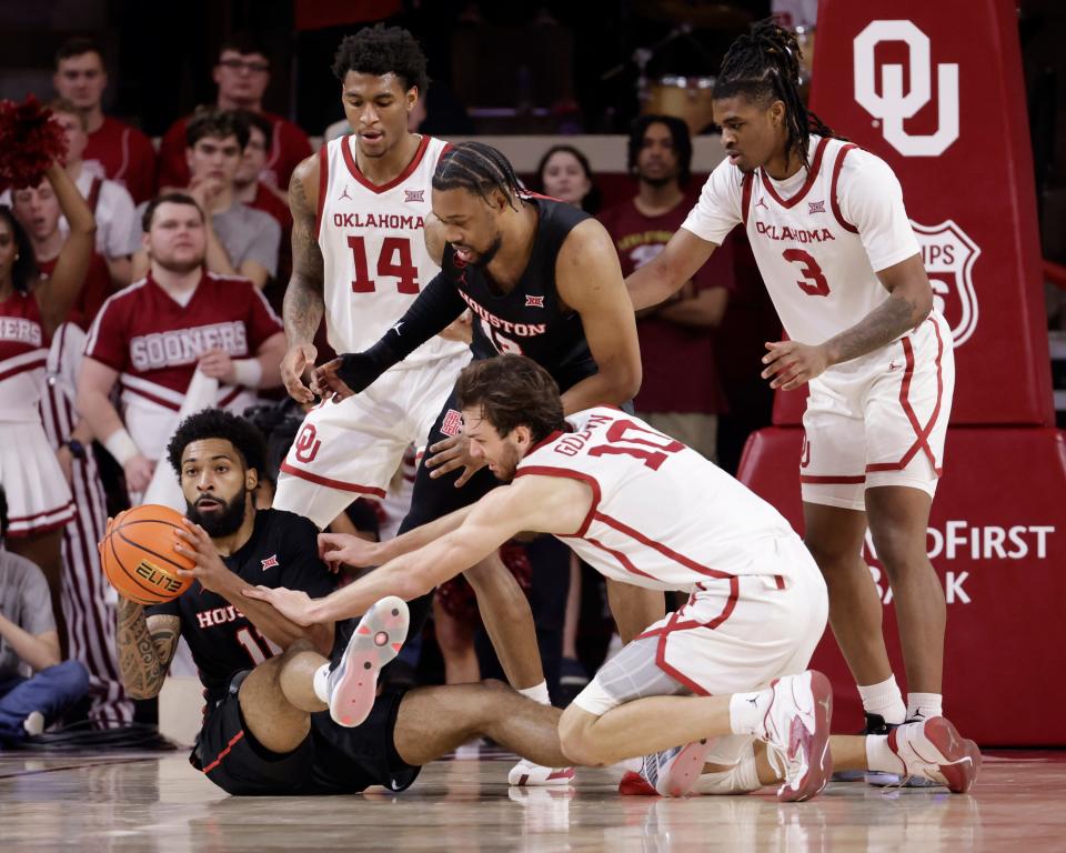 Houston's Damian Dunn passes the ball away from OU's Sam Godwin (10), while OU's Jalon Moore (14), Houston's J'Wan Roberts (13) and OU's Otega Oweh (3) look on during the second half Saturday in Norman.