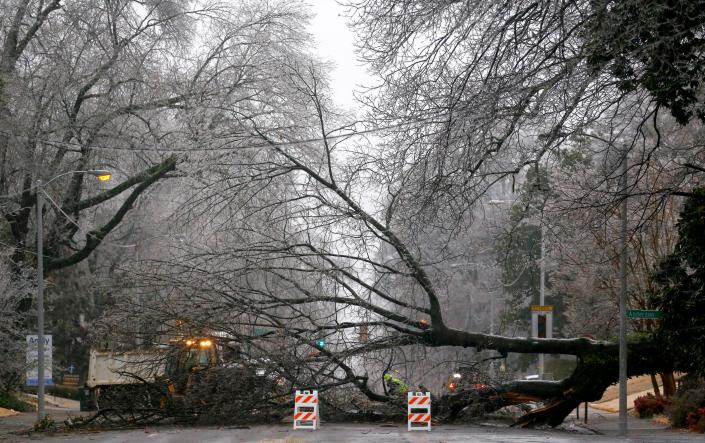A fallen tree is cleared from Central Avenue on Thursday, Feb. 3, 2022, in Memphis. The tree fell due to ice and blocked the road completely. Memphis could see up to a half-inch of ice today as a result of Winter Storm Landon. 