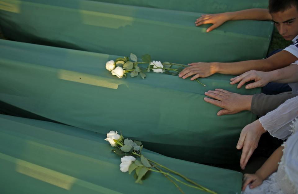 Bosnian Muslims cry near the coffin of a relative before a mass funeral for bodies found in a mass grave, in Kozarac, near Prijedor, July 19, 2014. (REUTERS/Dado Ruvic)