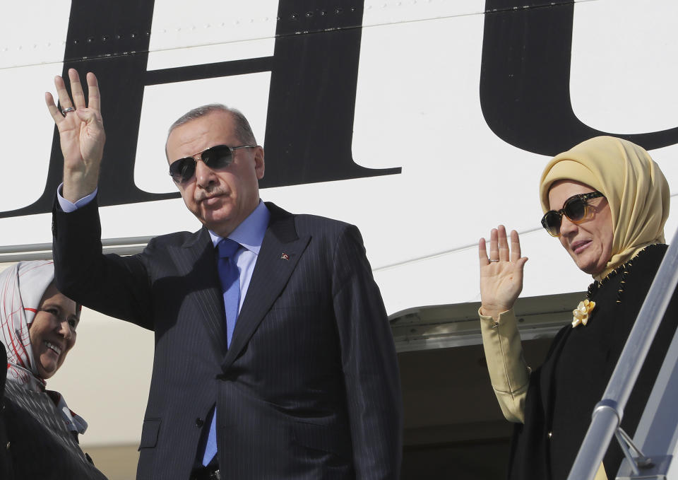 Turkish President Recep Tayyip Erdogan and his wife Emine Erdogan wave as they board a plane before a visit to the United States, in Ankara, Turkey, Tuesday, Nov. 12, 2019. Erdogan warned European nations Tuesday that his country could release all the Islamic State group prisoners it holds and send them to Europe, in response to EU sanctions over Cyprus.(Presidential Press Service via AP, Pool)