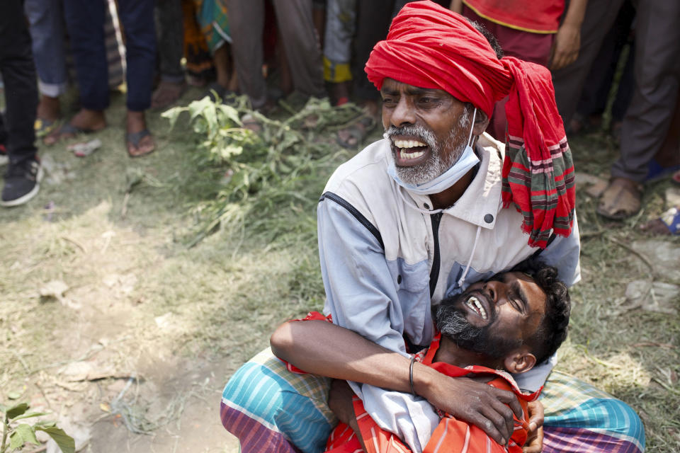 Relatives cry as rescuers recover bodies after a ferry sank Sunday night after being hit by a cargo vessel in the Shitalakkhya River in Narayanganj district, outside Dhaka, Bangladesh, Monday, April 5, 2021. (AP Photo/Mushfiqul Alam)