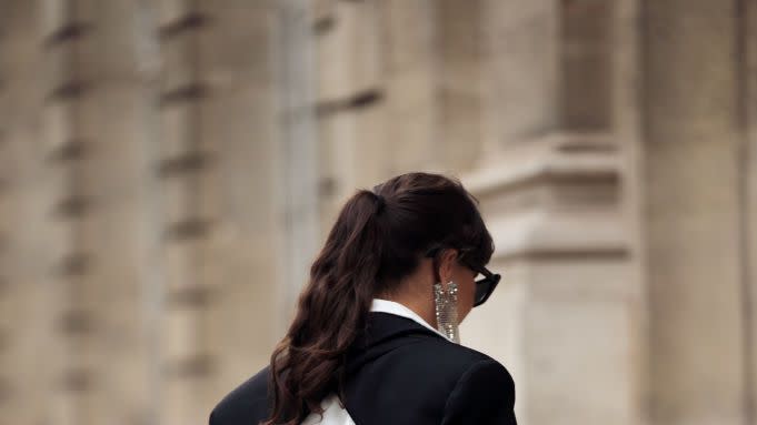 a woman wearing an open back black and white blazer and trousers on the street during paris fashion week spring summer 2023