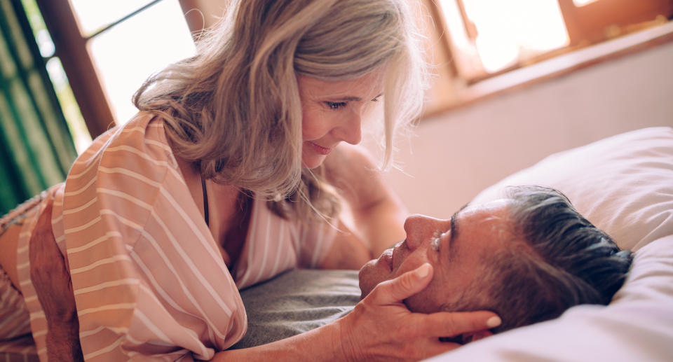 older man and woman intimate on bed
