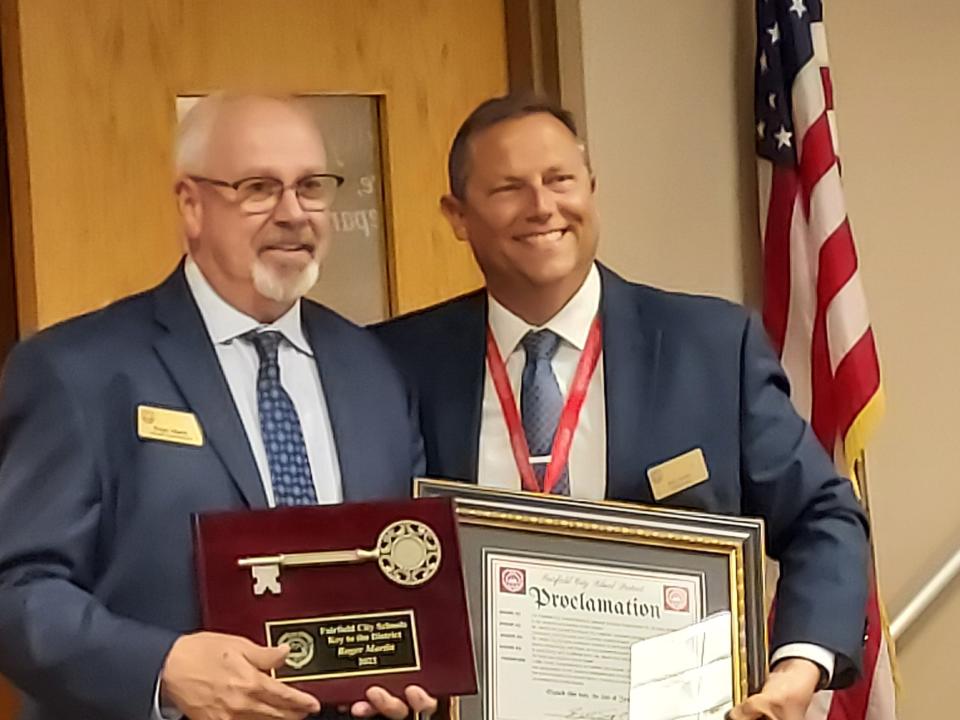 Retiring assistant superintendent Roger Martin, left, was presented with a proclamation and key to the district by Superintendent Billy Smith.